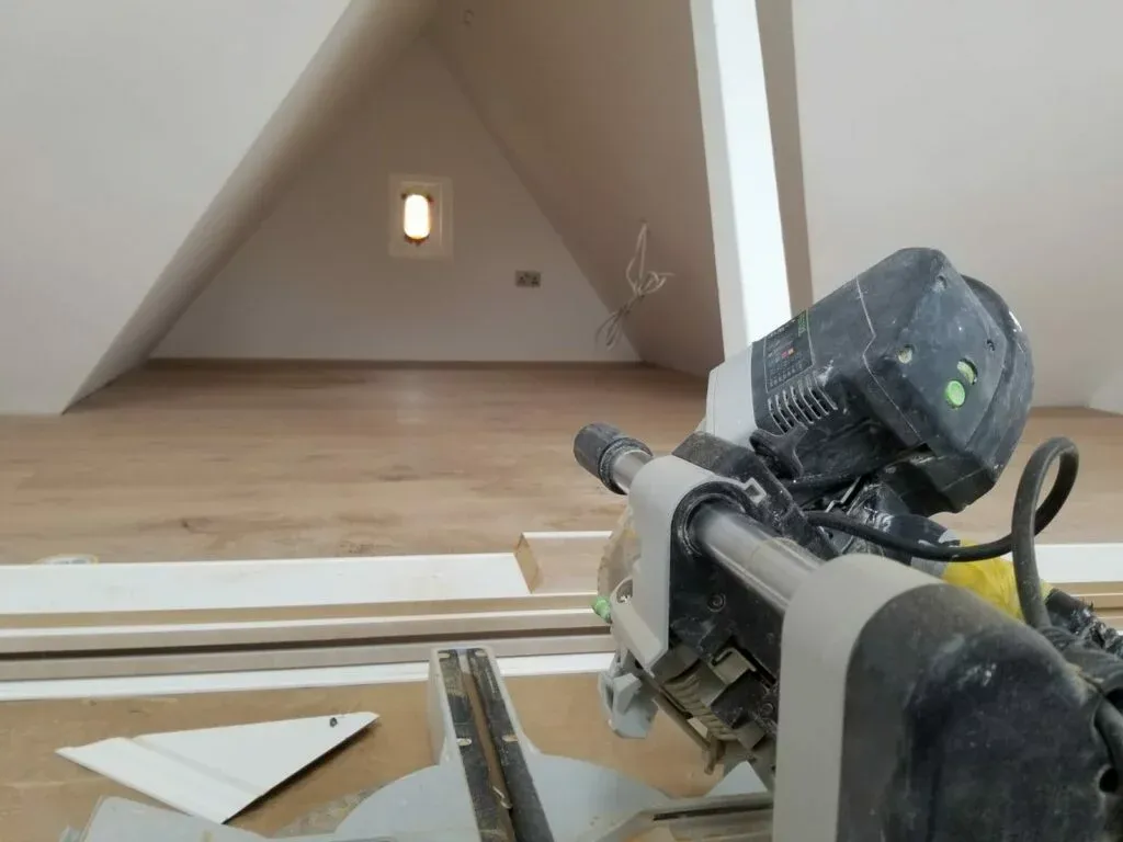Second-fix joinery in the roof room — saw bench in the foreground, new boards laid over the insulated build-up